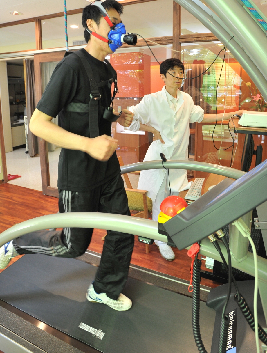 トレッドミル(ランニングマシン)上で、心肺運動負荷試験を受けている人